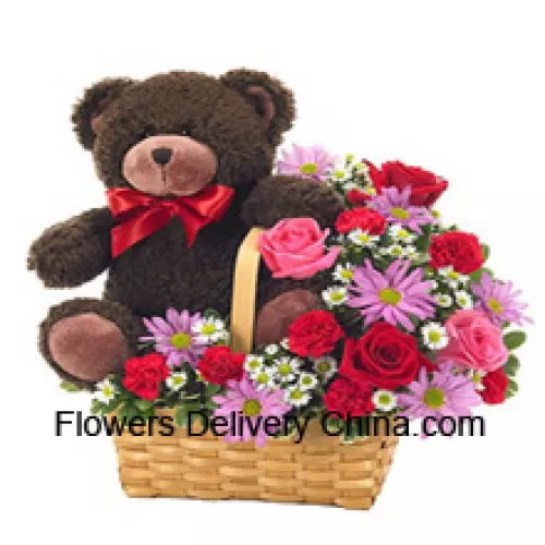 Un magnifique panier composé de roses rouges et roses, de œillets rouges et d'autres fleurs assorties de couleur violette accompagné d'un mignon ourson de 14 pouces de hauteur
