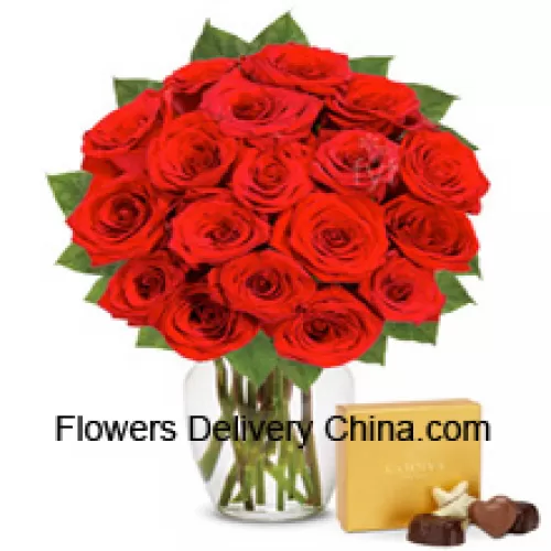 24 Red Roses With Some Ferns In A Glass Vase Accompanied With An Imported Box Of Chocolates