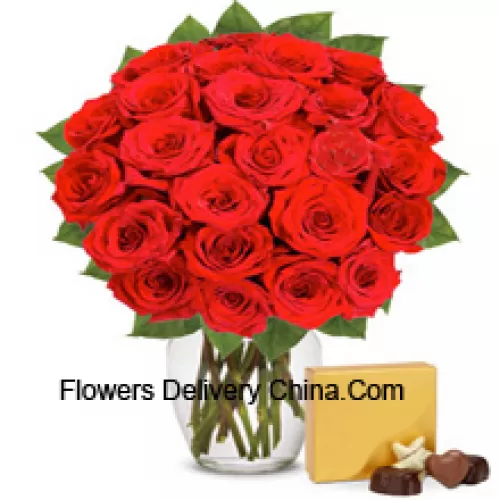 30 Rosas rojas con algunos helechos en un jarrón de vidrio acompañadas de una caja de chocolates importados