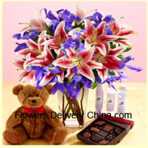 الزنابق الوردية والزهور البنفسجية المتنوعة مرتبة بشكل جميل في مزهرية زجاجية ، دمية دب براون طولها 12 بوصة وصندوق مستورد من الشوكولاتة