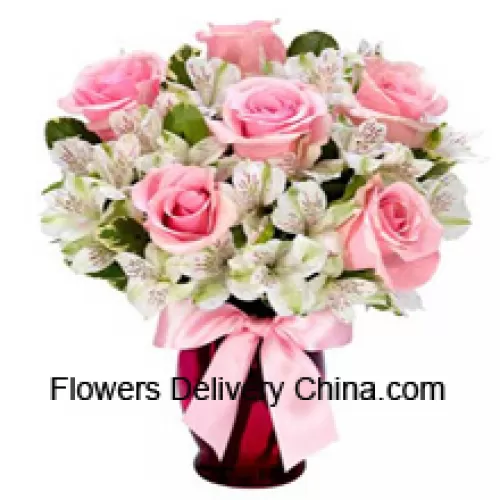 Roses roses et alstroemeria blanche arrangées magnifiquement dans un vase en verre