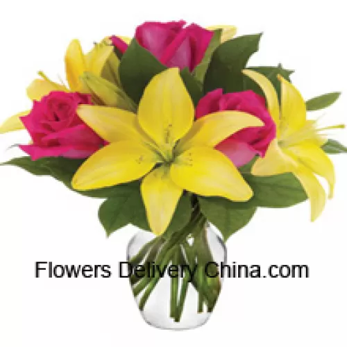 Roses roses et lis jaunes avec des garnitures saisonnières arrangés magnifiquement dans un vase en verre