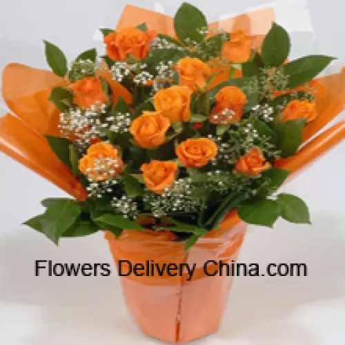 Un bel arrangement de 18 roses orange avec des remplisseurs saisonniers